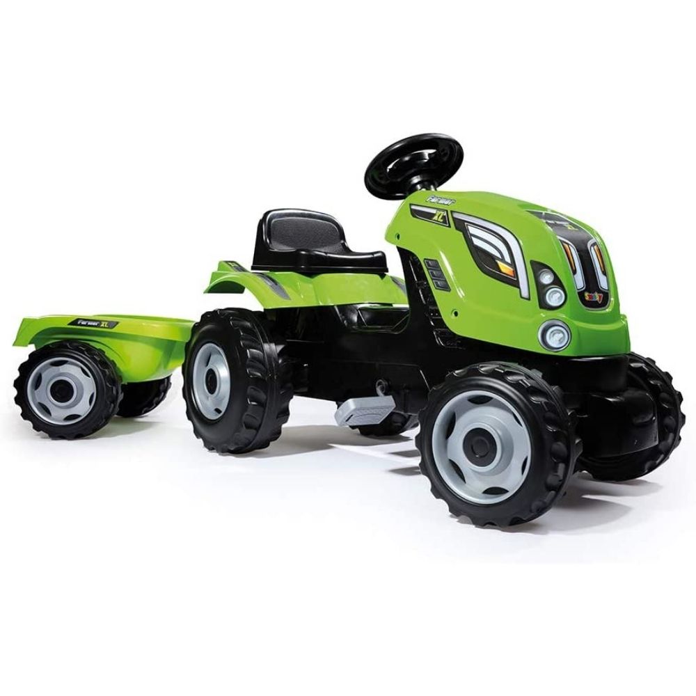 A green pedal ride-on tractor with trailer